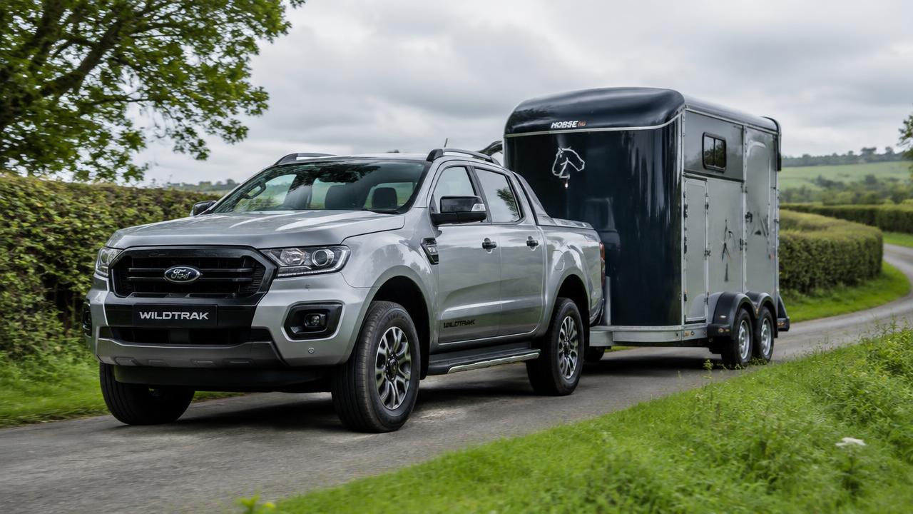 Silver Ford Ranger Wildtrak pickup towing a horsebox on an English country lane